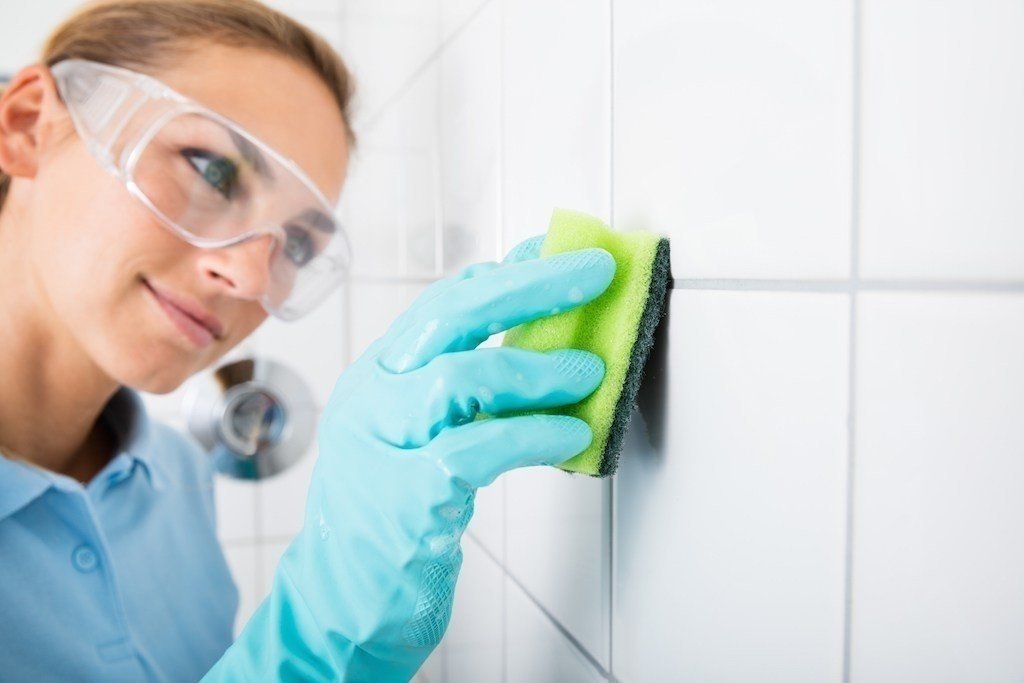 Woman cleaning tile with sponge