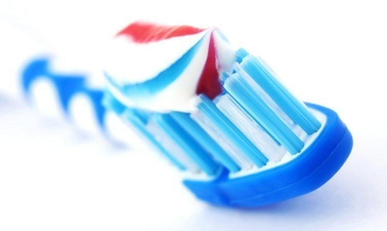 Зубная паста и щетка на белом фоне